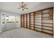 Spacious bedroom with plush carpet and an impressive custom-built wooden bookcase at 33624 Dolores Ct, Leesburg, FL 34788