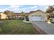 Attractive one-story home with a red roof, manicured lawn and driveway leading to the garage at 33624 Dolores Ct, Leesburg, FL 34788