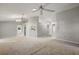 Expansive living room with neutral walls, carpeted floors, and multiple ceiling fans for comfort at 33624 Dolores Ct, Leesburg, FL 34788