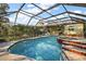 A screened-in pool and hot tub with brick trim and a view of the house at 33624 Dolores Ct, Leesburg, FL 34788