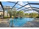 Screened-in pool features a connected spa and a stone patio at 33624 Dolores Ct, Leesburg, FL 34788