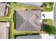 Birds-eye view of a well-maintained roof, lush green lawn and driveway with a parked car at 3373 Melbourne Ln, The Villages, FL 32163