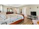 Bedroom with wood floors, TV and view of ensuite bathroom and kitchen at 3373 Melbourne Ln, The Villages, FL 32163