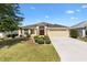 Inviting single-Gathering home featuring a two-car garage, arched entryway, and meticulously kept landscaping at 3373 Melbourne Ln, The Villages, FL 32163