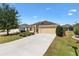 Charming single-story home boasting a two-car garage, well-manicured lawn and large driveway at 3373 Melbourne Ln, The Villages, FL 32163