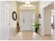 Bright and spacious foyer with tile flooring, a decorative mirror, and an elegant white front door at 3373 Melbourne Ln, The Villages, FL 32163
