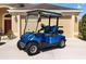 Close up view of a blue golf cart with black seats parked on a concrete driveway at 3373 Melbourne Ln, The Villages, FL 32163
