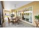 Relaxing lanai with dining area, ceiling fan, and views of the lush backyard at 3373 Melbourne Ln, The Villages, FL 32163