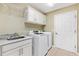 Clean laundry room with modern washer and dryer, a sink, and white cabinets at 3373 Melbourne Ln, The Villages, FL 32163