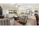 Bright living room with wood floors, neutral-toned sofas, and large windows overlooking the backyard at 3373 Melbourne Ln, The Villages, FL 32163