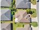 Overhead view of a home featuring a brown roof, green lawn, and mature trees in a neighborhood at 3405 Rabbit Run Path, The Villages, FL 32163