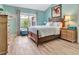 Bright bedroom with stylish wood-look floors, blue walls, and natural light at 3405 Rabbit Run Path, The Villages, FL 32163