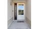 A clean entry with a white door, a decorative sidelight, and a welcoming 'hello' door mat at 3405 Rabbit Run Path, The Villages, FL 32163