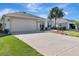 Charming home with a well-manicured lawn, a paved driveway, and an attached two-car garage at 3405 Rabbit Run Path, The Villages, FL 32163