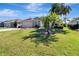 Charming home with a well-manicured lawn, mature palm trees, and lush landscaping at 3405 Rabbit Run Path, The Villages, FL 32163