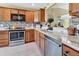 Modern kitchen features wood cabinets, stainless steel appliances, and stylish tile backsplash at 3405 Rabbit Run Path, The Villages, FL 32163