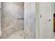 Modern shower with neutral colored tile, a built-in seat, and a convenient grab bar at 3405 Rabbit Run Path, The Villages, FL 32163