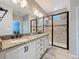 Bathroom with a double vanity with granite countertop, a walk-in shower and modern fixtures at 345 Alcove Dr, Groveland, FL 34736