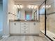 Bathroom showcasing a double vanity with granite countertop, and a walk-in shower with glass door at 345 Alcove Dr, Groveland, FL 34736