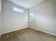 Empty carpeted bedroom illuminated by two windows offering natural light at 345 Alcove Dr, Groveland, FL 34736