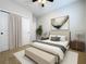 A staged bedroom with a decorative painting, queen bed, and two nightstands at 345 Alcove Dr, Groveland, FL 34736