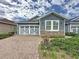 Beautiful single-Gathering home featuring a brick driveway and a stylish two-car garage at 345 Alcove Dr, Groveland, FL 34736