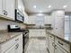 Well-equipped kitchen with granite countertops, stainless steel appliances, white cabinets and modern fixtures at 345 Alcove Dr, Groveland, FL 34736