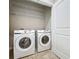 Bright laundry room with white washer and dryer and wire shelving above at 345 Alcove Dr, Groveland, FL 34736