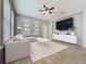 Stylishly staged living room featuring a modern sofa, large TV, and lots of natural light at 345 Alcove Dr, Groveland, FL 34736