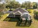 Aerial view of the back of the house featuring a screened lanai and in-ground pool surrounded by greenery at 36845 Taylor Mill Rd, Fruitland Park, FL 34731