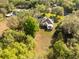 Aerial view of the home, set amongst trees, featuring a screened-in lanai and pool at 36845 Taylor Mill Rd, Fruitland Park, FL 34731