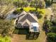 Aerial view of home with screened lanai and in-ground pool, surrounded by lush landscaping and mature trees at 36845 Taylor Mill Rd, Fruitland Park, FL 34731