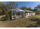 An overview of the house with its well manicured lawn and screened in lanai at 36845 Taylor Mill Rd, Fruitland Park, FL 34731