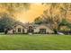 Inviting single-story home featuring a manicured lawn, mature trees, and traditional architectural details at 36845 Taylor Mill Rd, Fruitland Park, FL 34731