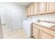 A large laundry room with cabinets, utility sink, and a washer and dryer at 36845 Taylor Mill Rd, Fruitland Park, FL 34731