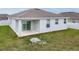 A home's exterior rear view features a covered patio and a grassy yard, perfect for outdoor enjoyment at 37031 Lake Overlook Dr, Grand Island, FL 32735