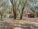 Property featuring a metal building and a cabin with a porch set among mature trees at 37820 Ridgecrest Ln, Lady Lake, FL 32159