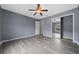 This bedroom features hardwood floors, a ceiling fan, and a mirrored closet at 3900 Sw 102Nd Pl, Ocala, FL 34476