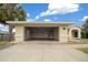 Large two-car garage with an open door and a view of the home at 3900 Sw 102Nd Pl, Ocala, FL 34476