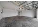 Spacious garage with concrete floors, door, and overhead lighting provides ample parking and storage at 3900 Sw 102Nd Pl, Ocala, FL 34476