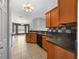 Kitchen features wood cabinets, tiled flooring and backsplash, a breakfast bar, and modern black appliances at 3900 Sw 102Nd Pl, Ocala, FL 34476
