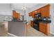 Well-lit kitchen features wood cabinetry, tiled backsplash, and a breakfast bar overlooking an adjacent dining area at 3900 Sw 102Nd Pl, Ocala, FL 34476
