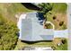Aerial shot of home featuring mature trees, landscaping, a driveway and a backyard patio and sunroom at 3909 River Crest Cir, Leesburg, FL 34748