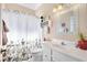 Cozy bathroom featuring a decorative shower curtain and white vanity with a decorative mirror at 3909 River Crest Cir, Leesburg, FL 34748