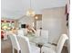 Open dining room layout adjoining the living room, featuring a glass table, chandelier, and light neutral walls at 3909 River Crest Cir, Leesburg, FL 34748