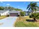 Charming single-story home features a two-car garage, tropical landscaping, and a well-manicured lawn at 3909 River Crest Cir, Leesburg, FL 34748