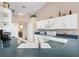 Bright kitchen with white cabinets, green countertops, white appliances, and view to the laundry room at 3909 River Crest Cir, Leesburg, FL 34748