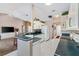 Open layout of a kitchen and living area featuring white appliances, white cabinets, and neutral color walls at 3909 River Crest Cir, Leesburg, FL 34748