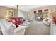 Spacious living room with large windows, neutral color palette, and views to the screened patio at 3909 River Crest Cir, Leesburg, FL 34748