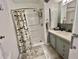 Bright bathroom features a shower, vanity, and patterned shower curtain at 405 Hawthorne Blvd, Leesburg, FL 34748